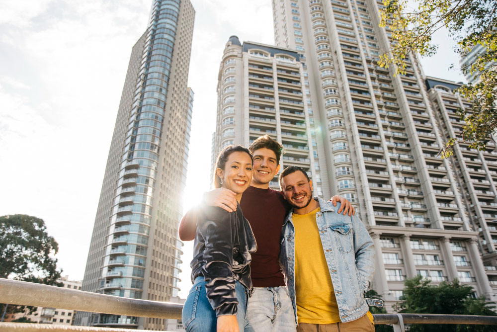 multiracial-young-friends-standing-against-city-buildings